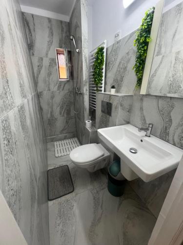 a bathroom with a sink and a toilet at Emmaia Escape Eforie Nord in Eforie Nord