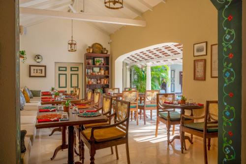 a dining room with wooden tables and chairs at The Sun House in Galle