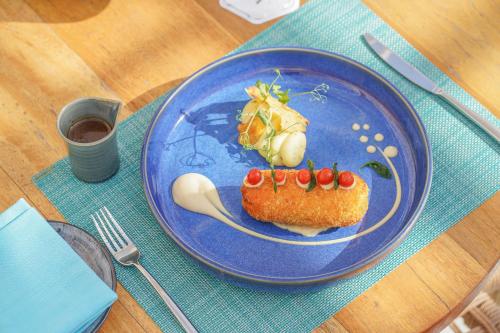 a blue plate with a piece of food on a table at Waldorf Astoria Ras Al Khaimah in Ras al Khaimah