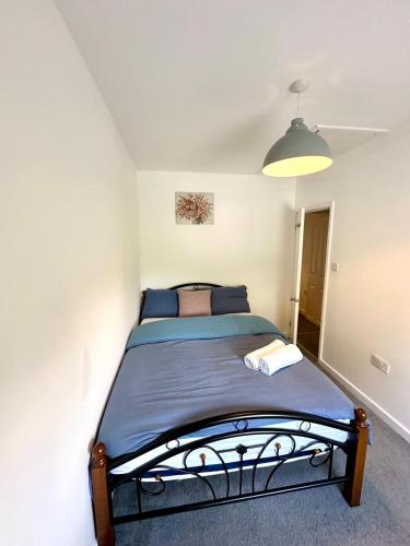 a bedroom with a bed in a white room at Spacious 2-Bed Home with Garden in Thornton Heath