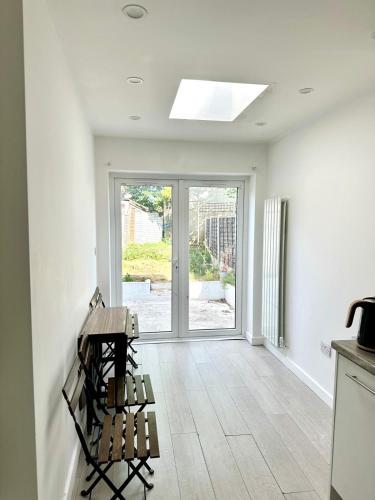 a white room with a table and a window at Spacious 2-Bed Home with Garden in Thornton Heath