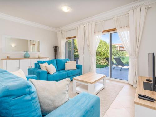 a living room with a blue couch and a table at Relax and golf at Boavista Golf Spa Resort #1968 in Lagos