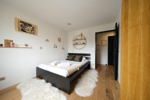 een slaapkamer met een bed en een wit tapijt bij Rouen - Bienvenue chez Aurélie in Rouen