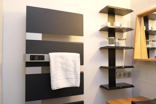 een badkamer met zwart-witte handdoeken aan de muur bij Rouen - Bienvenue chez Aurélie in Rouen