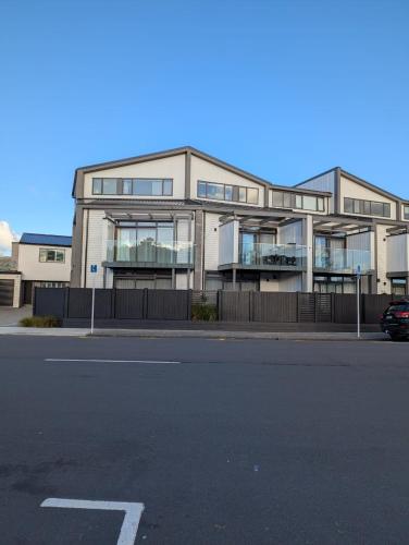 a large building with a parking lot in front of it at Lower Hutt Central Brand New 3 bedroom 2 Bath Spacious House Balcony Private garage in Lower Hutt