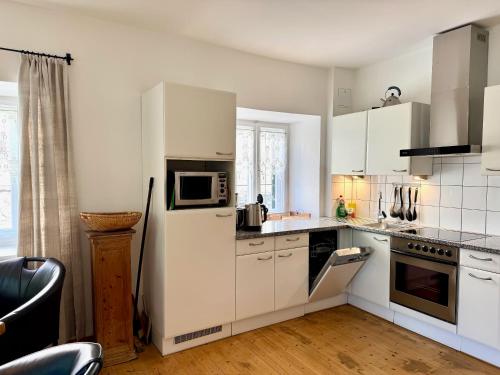 a kitchen with white cabinets and a refrigerator at Appartements Greier in Telfes im Stubai