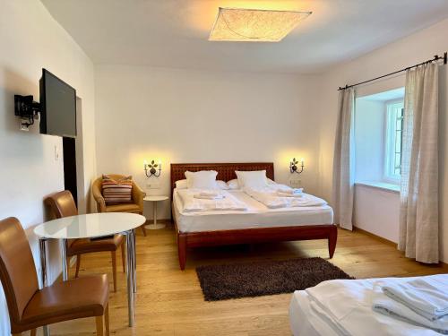 a bedroom with a bed and a table and chairs at Appartements Greier in Telfes im Stubai