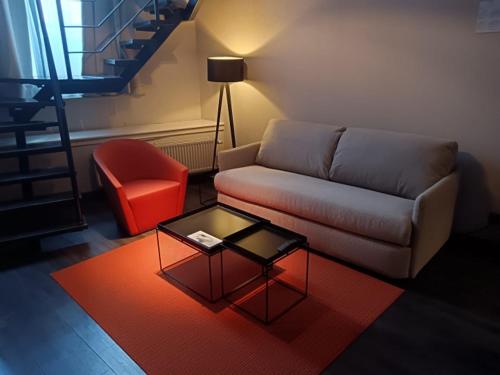 a living room with a couch and a table and a chair at Atlas Hotel Brussels in Brussels