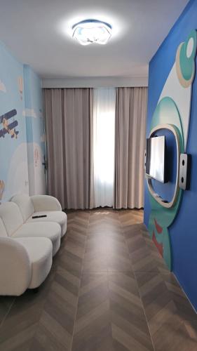 Una sala de estar con un sofá y un televisor. en Hermanos Apartment 110, en Shëngjin