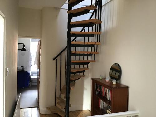 a spiral staircase in a living room with a book shelf at Bridge Villas in Garstang
