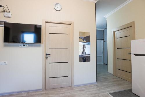 a room with two doors and a tv on a wall at Brand-New 2BR House with Garden in Tbilisi City