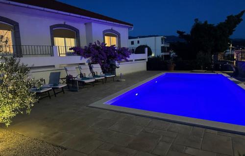 a blue swimming pool in front of a house at Villa Lara - Rab by Villas Guide in Rab