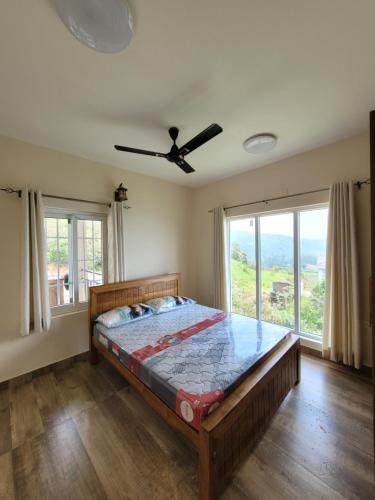 a bedroom with a bed in a room with windows at The Ark Haven Ooty in Kolakambe