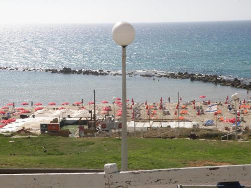 a beach with umbrellas and a bunch of people at Spat Beach in Bat Yam