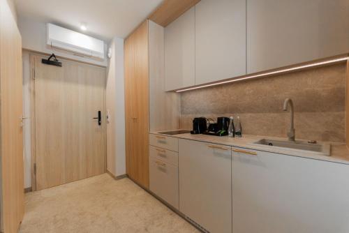 a kitchen with white cabinets and a sink at Sunny Rest in Seashell in Łukęcin