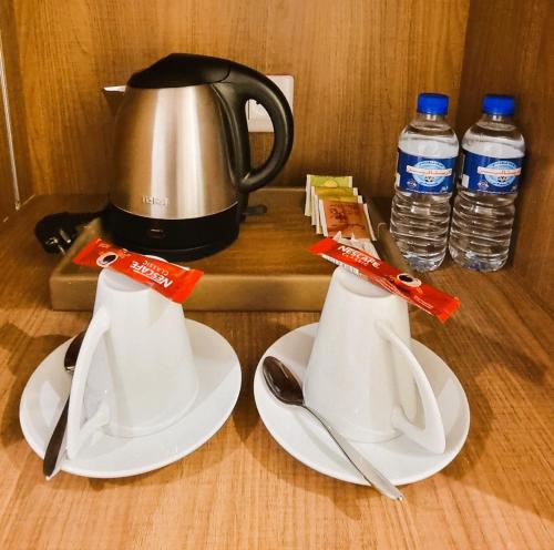 a tea kettle and two white plates and bottles of water at Sentido Marillia Resort & Spa in Hammamet