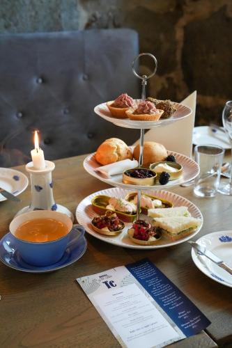 a table with three plates of food and a candle at Hotell Blå Blom in Gustavsberg