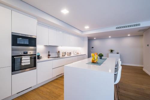 a kitchen with white cabinets and a white counter top at The Shoreline 2 in Parede