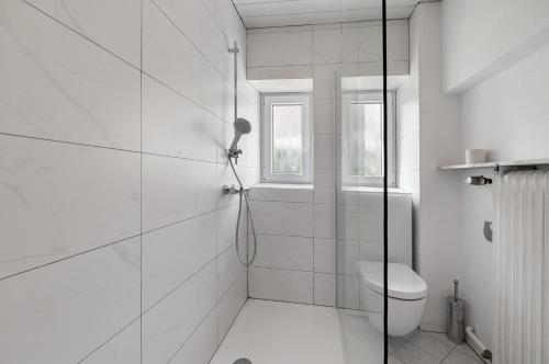 a white bathroom with a shower and a toilet at Ferienwohnung Merzig in Merzig