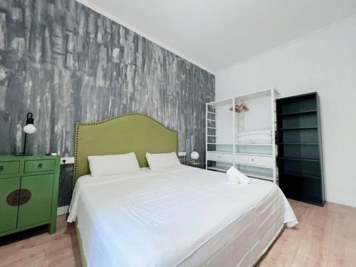 a bedroom with a white bed and a green wall at Habitación Plaza Zerolo A in Madrid