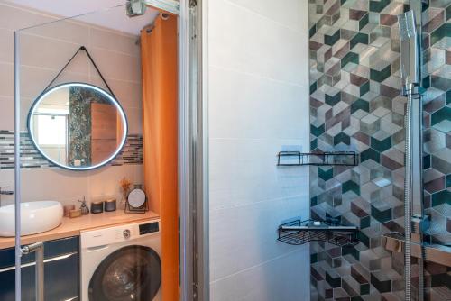 ein Badezimmer mit einer Waschmaschine und einem Spiegel in der Unterkunft Happy Home - Charmante Maison Proche Plage in Saint-Gildas-de-Rhuys
