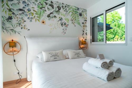 ein Schlafzimmer mit einem weißen Bett mit Handtüchern darauf in der Unterkunft Happy Home - Charmante Maison Proche Plage in Saint-Gildas-de-Rhuys