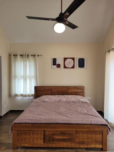 a bedroom with a bed with a ceiling fan at The Ark Haven Ooty in Kolakambe