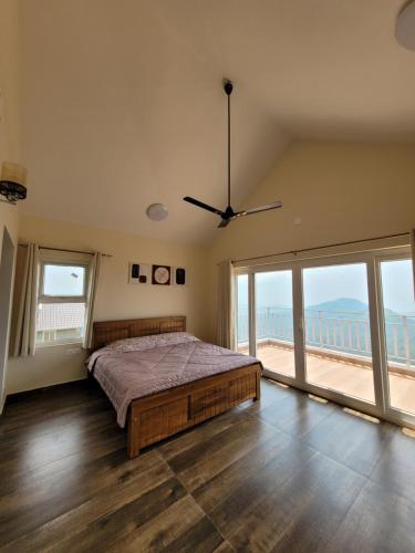 a bedroom with a bed and a large window at The Ark Haven Ooty in Kolakambe