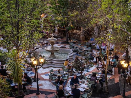 an overhead view of a park with people sitting at tables and a fountain at The Windhoek Luxury Suites in Windhoek