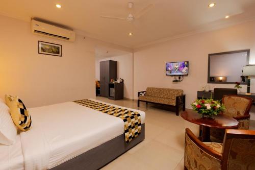 a hotel room with a bed and a living room at Hotel Gopalapuram International in Pollāchi