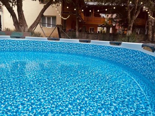 a large blue swimming pool with blue water at Tako's house in Mestia