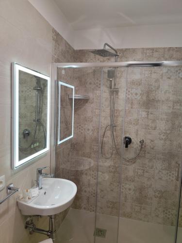 a bathroom with a sink and a glass shower at La Pietra 1911 in Ercolano