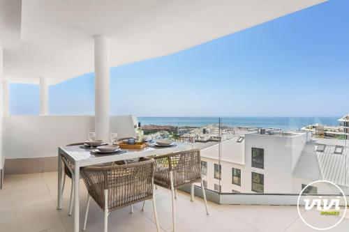 a balcony with a table and chairs and a view of the ocean at Mimosa in Fuengirola