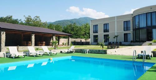 a resort with a swimming pool in front of a building at Tilia Kvareli Resort in Kvareli