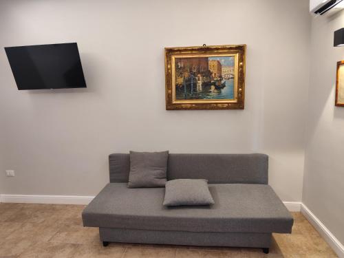 a couch in a living room with a picture on the wall at La Pietra 1911 in Ercolano