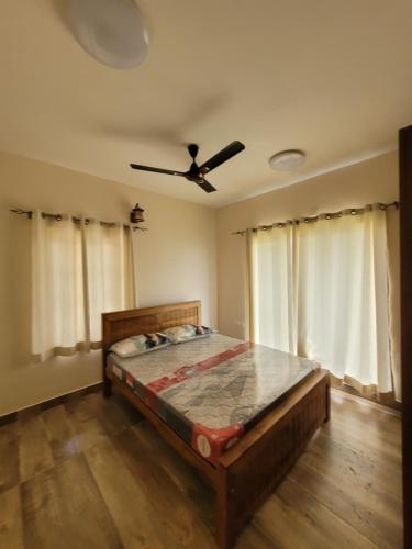 a bedroom with a bed and a ceiling fan at The Ark Haven Ooty in Kolakambe