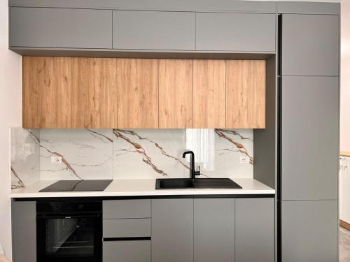 Una cocina con gabinetes blancos y un fregadero. en Talea Luxe Apartment, en Tale