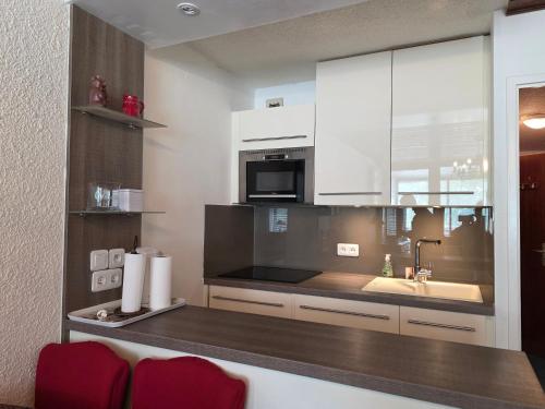 a kitchen with a counter with a sink and a microwave at Le Serac Panoramic Mountain View spacious 40m2 managed by private host in Val Thorens