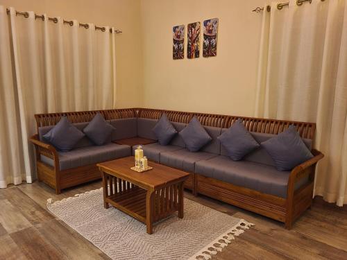 a living room with a couch and a table at The Ark Haven Ooty in Kolakambe