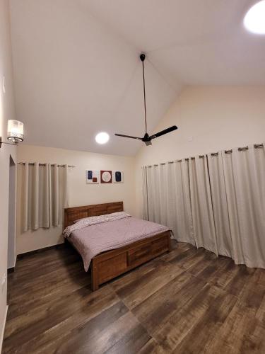 a bedroom with a bed and a ceiling fan at The Ark Haven Ooty in Kolakambe