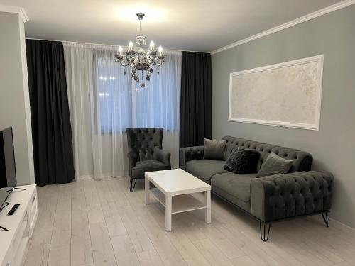a living room with a couch and two chairs at ЛУКСОЗНИ АПАРТАМЕНТИ ДАРИС-free parking in Kazanlŭk