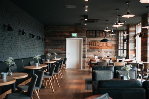 a restaurant with tables and chairs and a white door at Coffee Fellows Hotel Trier in Trier