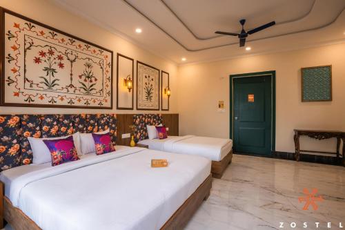 a bedroom with two beds and a green door at Zostel Agra in Agra