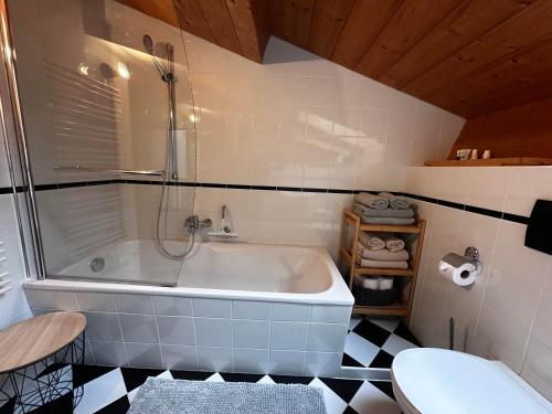 a bathroom with a tub and a toilet at Obinghof in Fieberbrunn