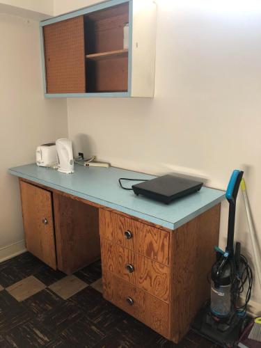 a desk with a laptop on top of it at Comfort cottage guest home near subway station, bus and downtown in Vancouver