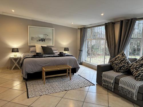 a bedroom with a bed and a couch at DullVino Wellington House in Dullstroom