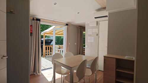 une cuisine et une salle à manger avec une table et des chaises dans l'établissement Mobilhome 6 personnes, à Cheval-Blanc