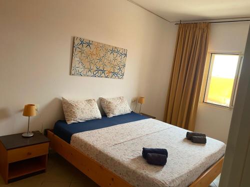 Un dormitorio con dos camas y una ventana. en MORADIAS I02/C, en Prainha