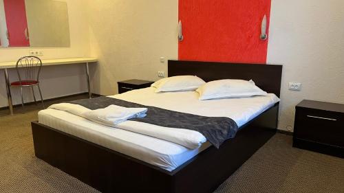 a bed with white sheets and pillows in a room at JEPPESEN RESIDENCE in Almaty