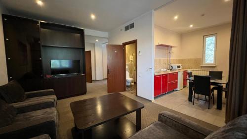 a living room with a couch and a table and a kitchen at JEPPESEN RESIDENCE in Almaty